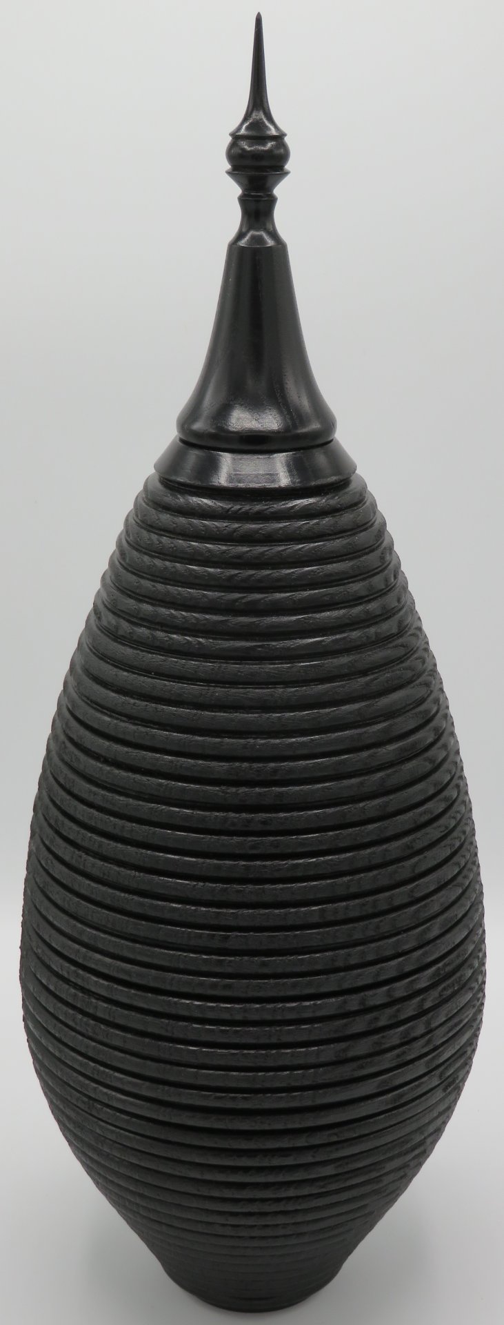 Ebonised ,beaded and texturned tall hollow form.